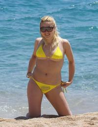 A busty bikini girl undressing on the Rarawa Nudist Image 3